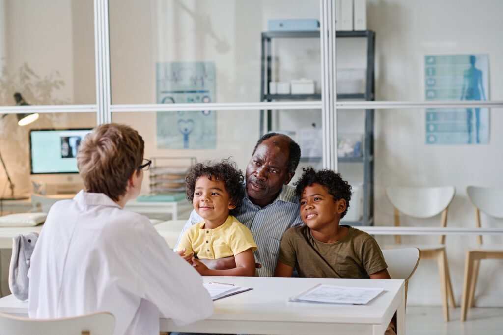 Dad with sons visiting doctor