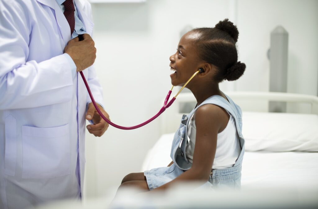 Friendly pediatrician entertaining his patient