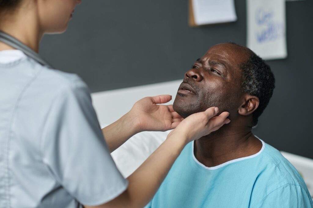 Nurse examining throat of patient